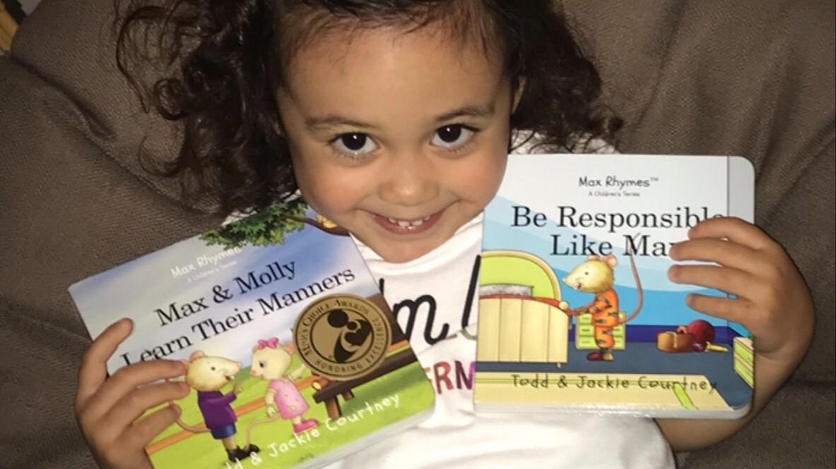 Young girl holding Max Rhymes book laughing, learning reading skills, positive behavior, core values, self-respect, respect for others